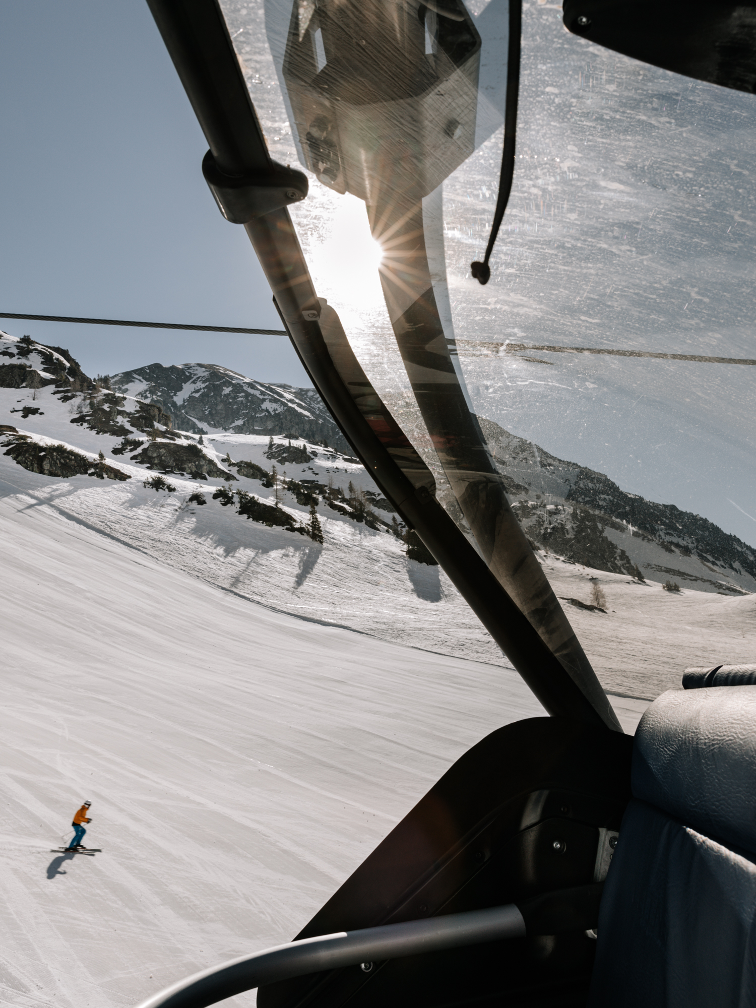 Fahrt mit dem Sessellift in Obertauern. Auf der Piste befindet sich ein Ski Alpin Fahrer.