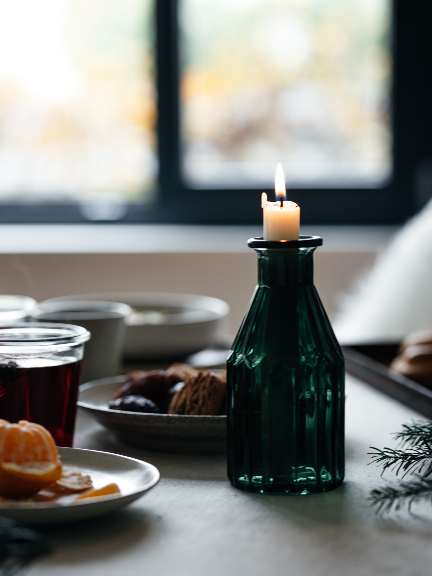 weihnachtlich gedeckter Frühstückstisch mit einer brennenden Kerze
