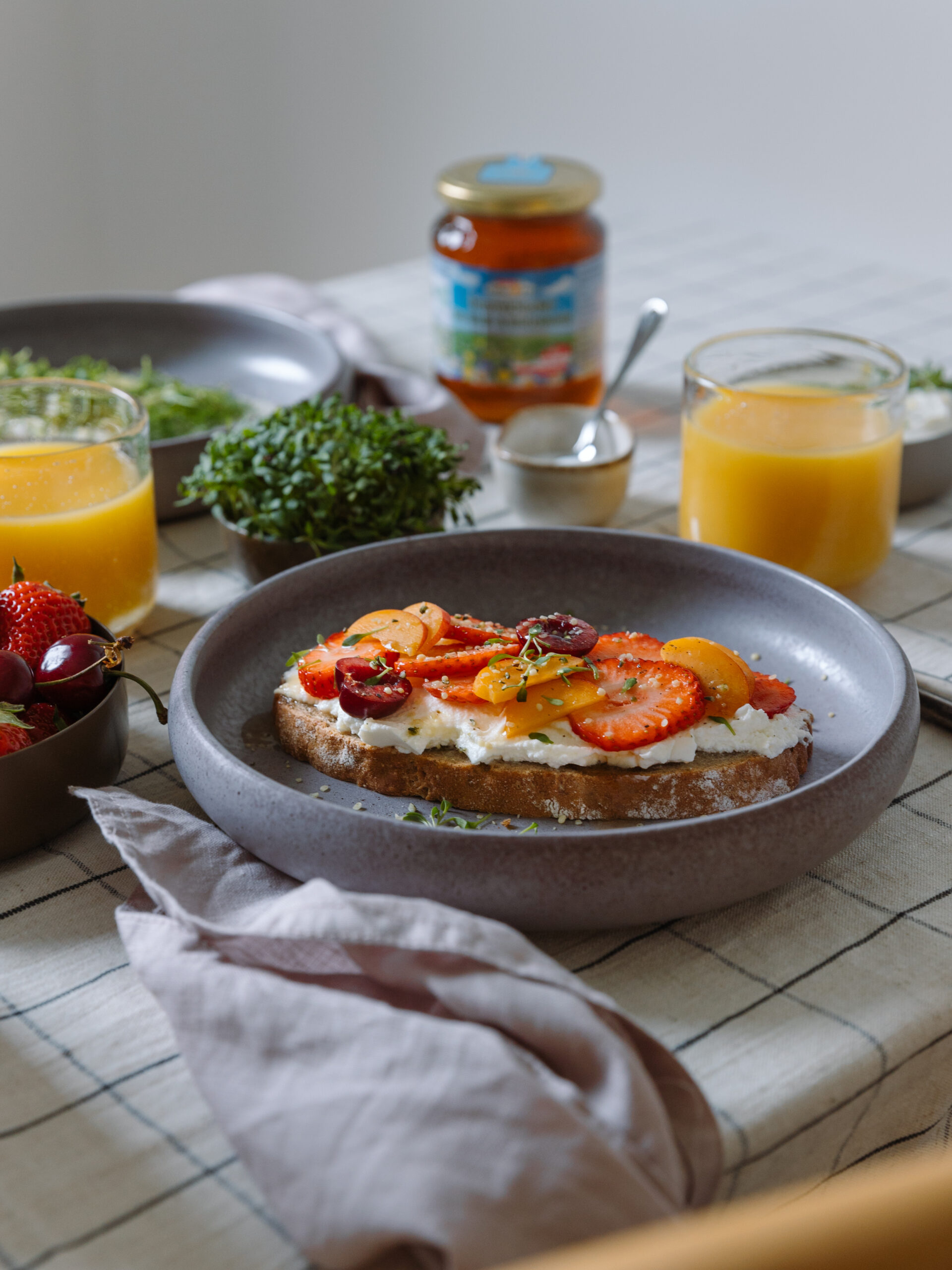 gedeckter Frühstückstisch mit Orangensaft und belegtem Brot